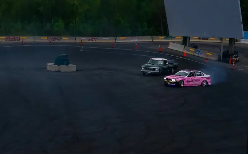 Pink Gernatt Pest Solutions drift car sliding around a speedway track